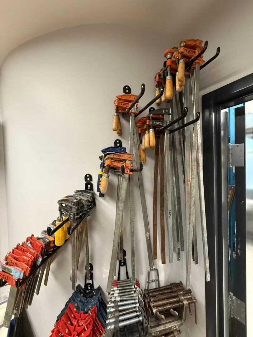 Wall of bar clamps and hand saws