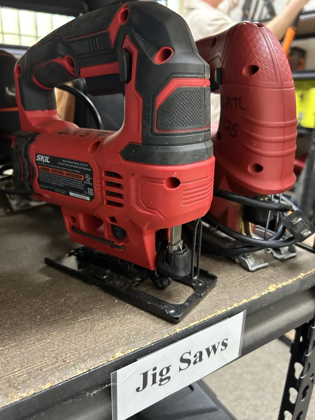 Red jig saws on a labeled shelf