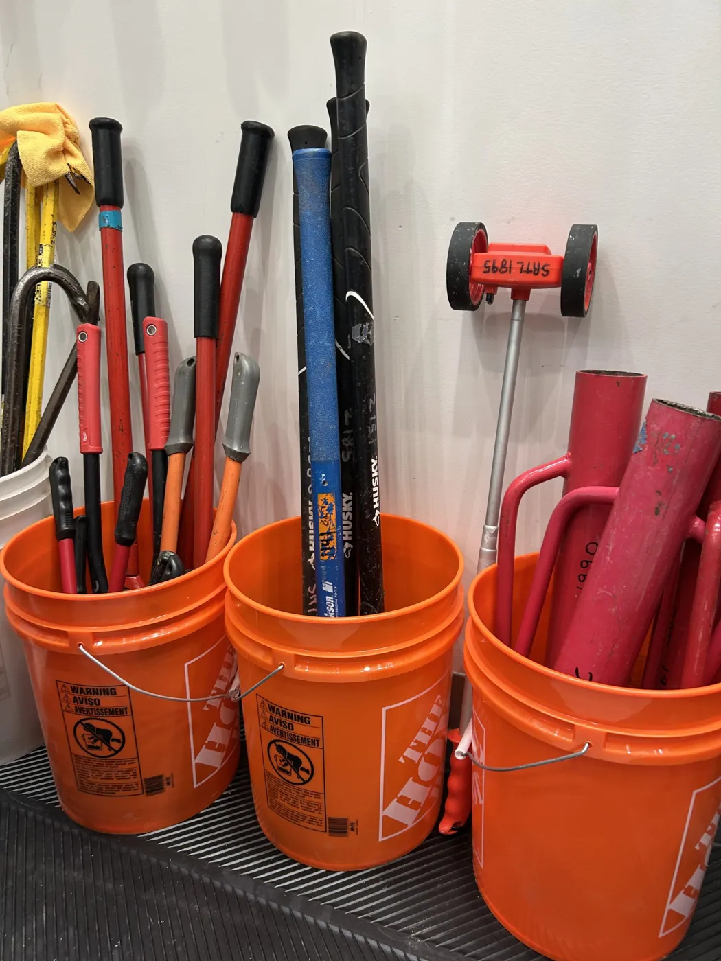 Orange buckets filled with long-handled tools
