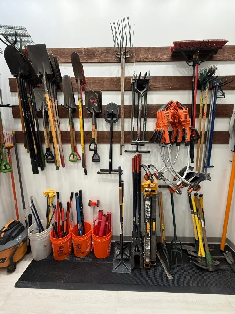 Wall of shovels, rakes, loppers and garden tools at the library