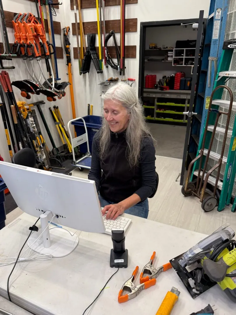 Volunteer checking out tools at the front desk